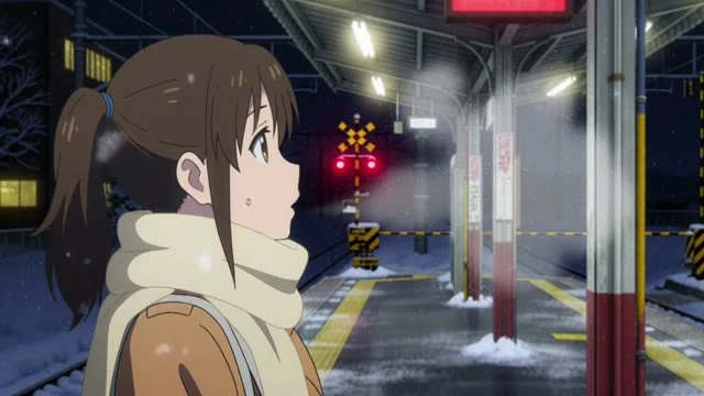 アニメのカット。雪の降る駅のホーム。マフラーの女子高生が白い息を吐き、電車が来る方を見て「あと少し」とつぶやく。遠くの踏切の音。